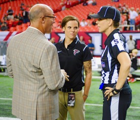 Scott Pioli, Katie Sowers and Sarah Thomas congregate on a NFL football field on game day.