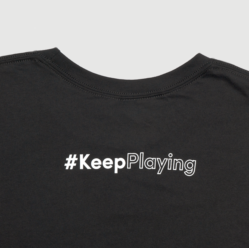 Back of black t-shirt with "#KeepPlaying" printed below the collar.