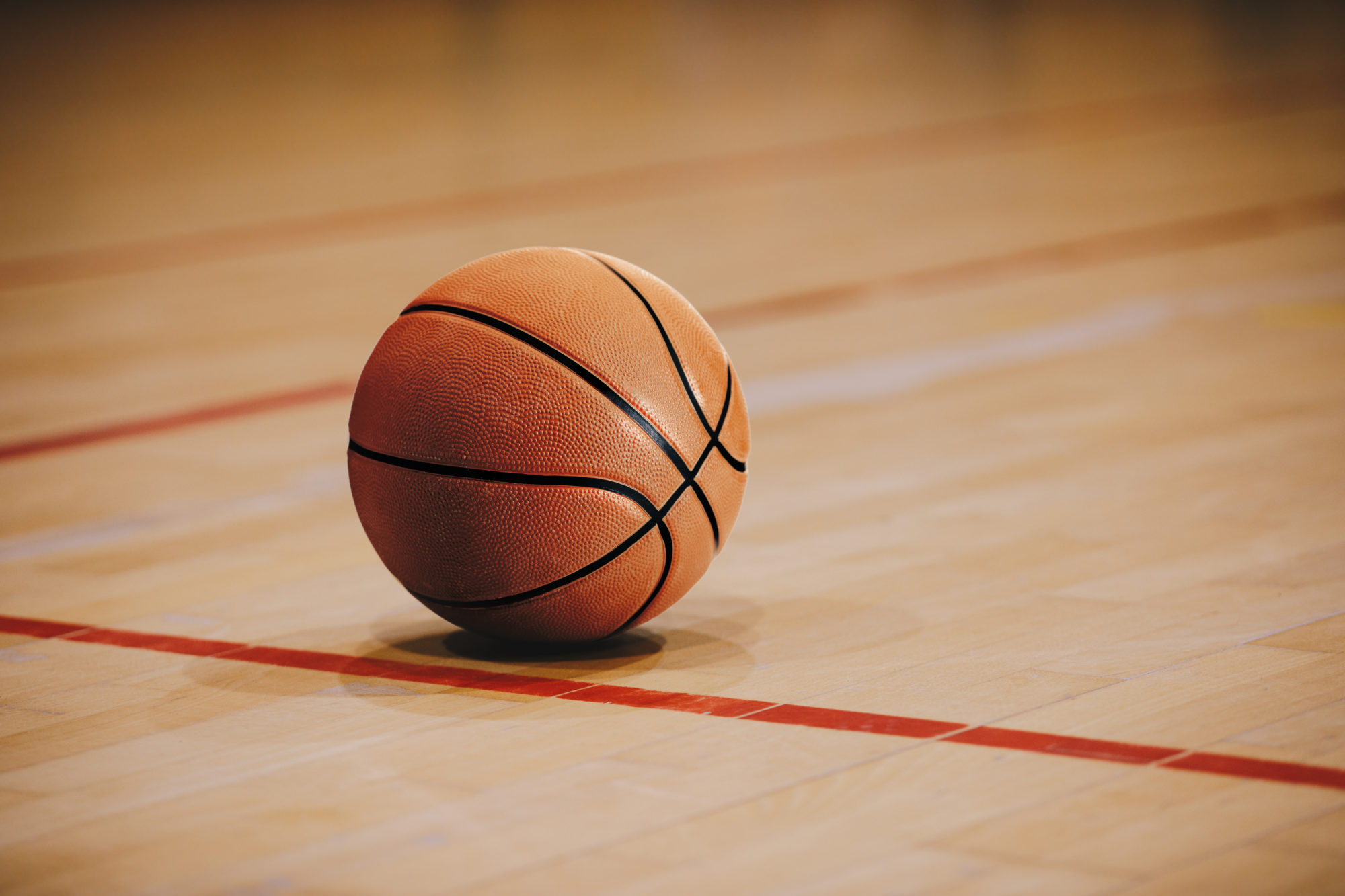 Classic Basketball on Wooden Court Floor Close Up with Blurred Arena in ...