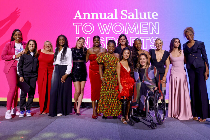 A group of elite women athletes gather on stage for a group photo at the Annual Salute to Women in Sports.