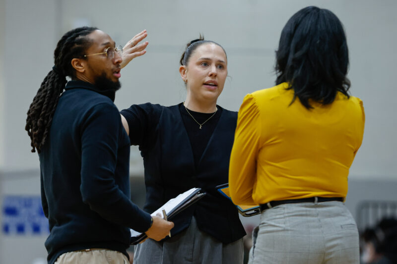 Coaches gather in a huddle during a game.